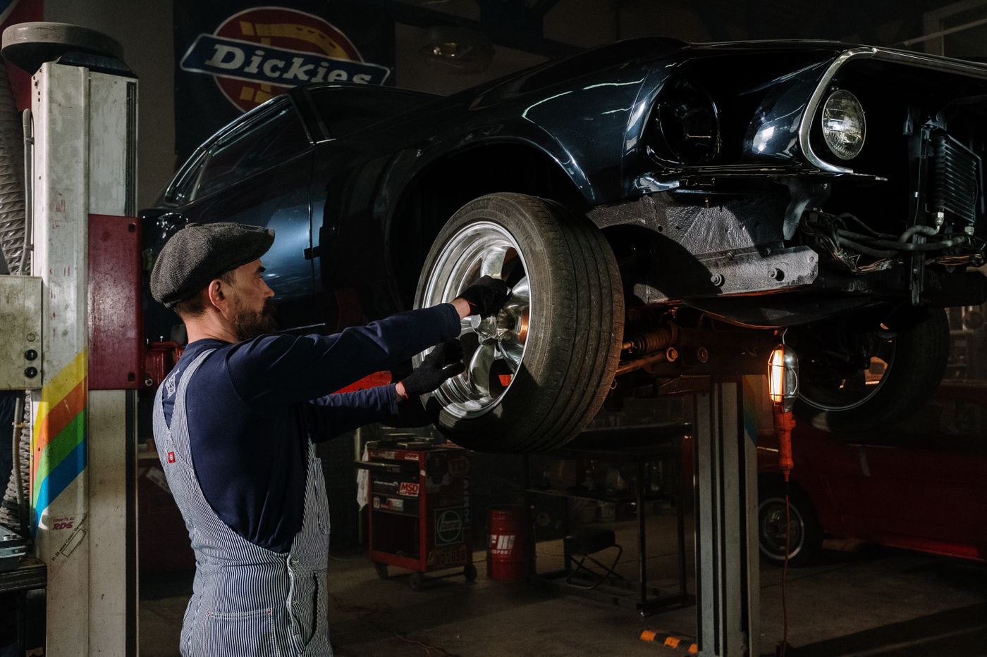 Driver checking tire pressure with a portable inflator in a driveway