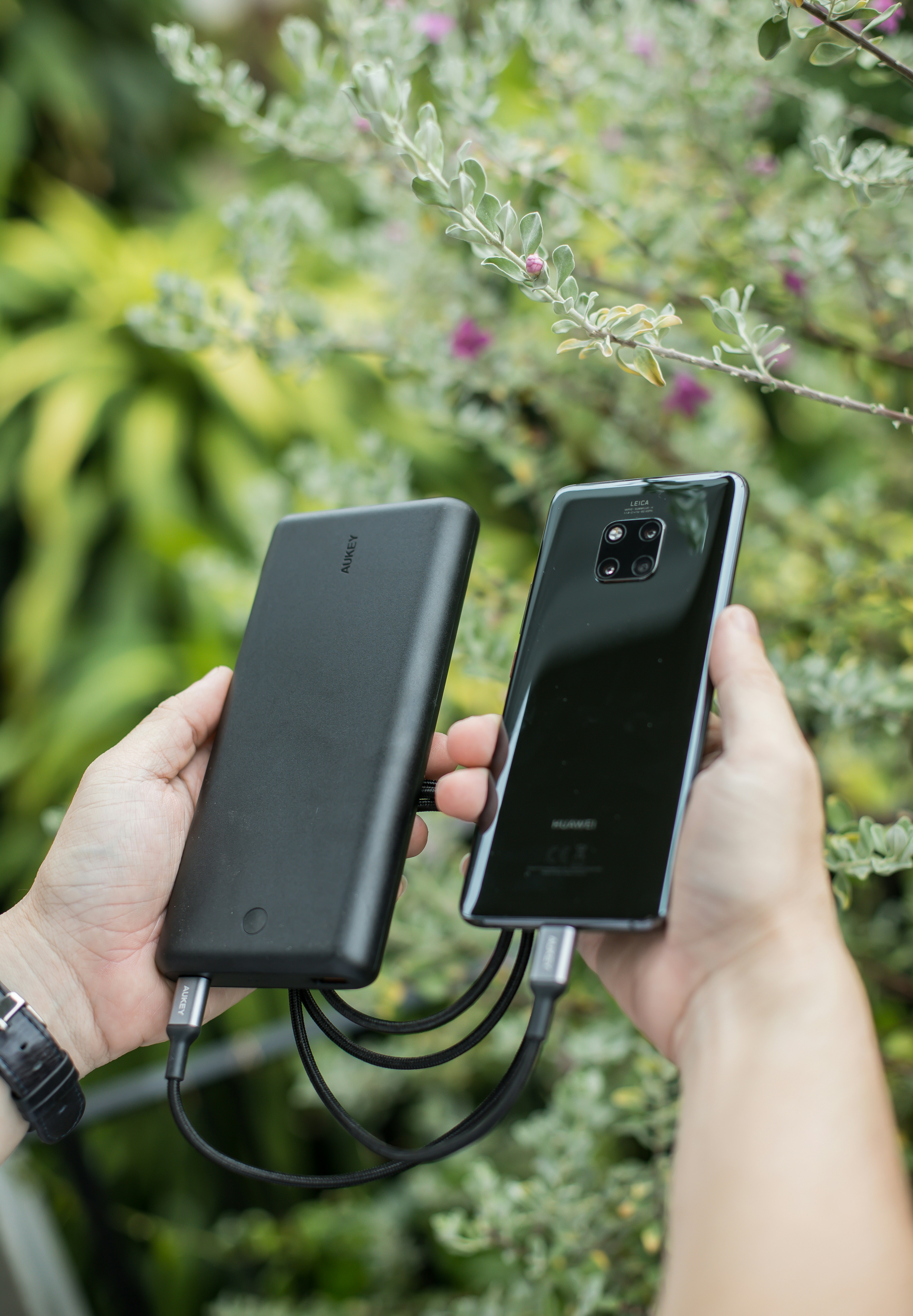 Traveler charging a phone from a portable battery at a station